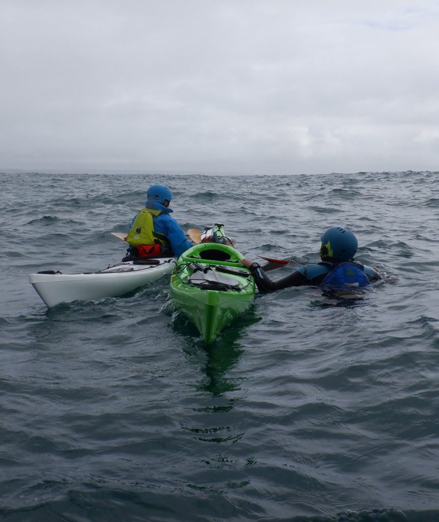 sea kayaker in the water being rescued