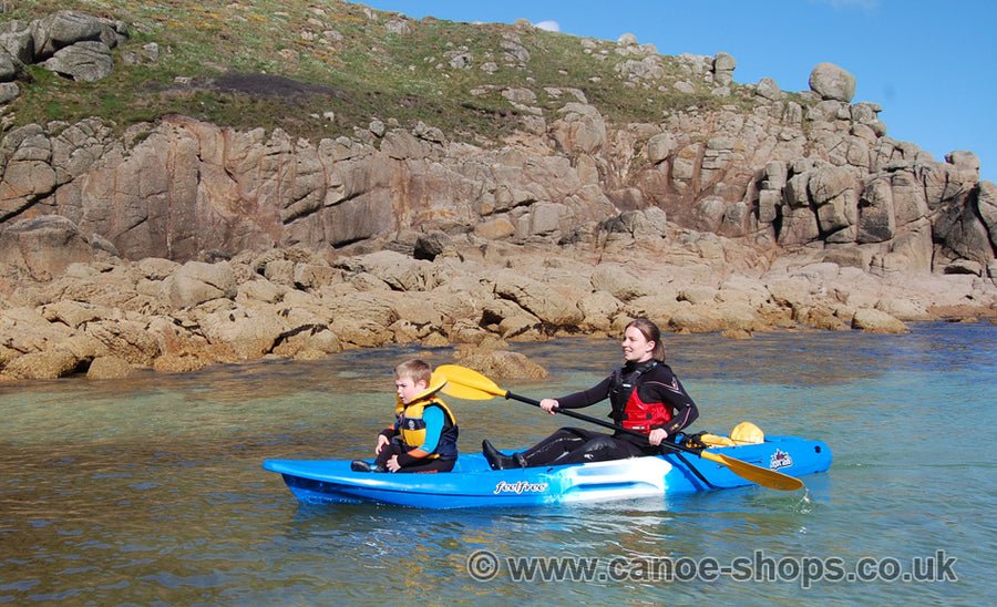Adult and child paddling a Feelfree Juntos sit-on-top kayak in Cornwall